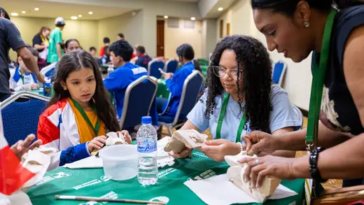 Tables of young players painting their masks