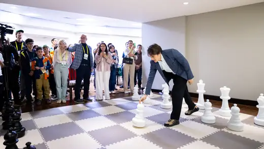 The master making a move on the giant board as the audience watches